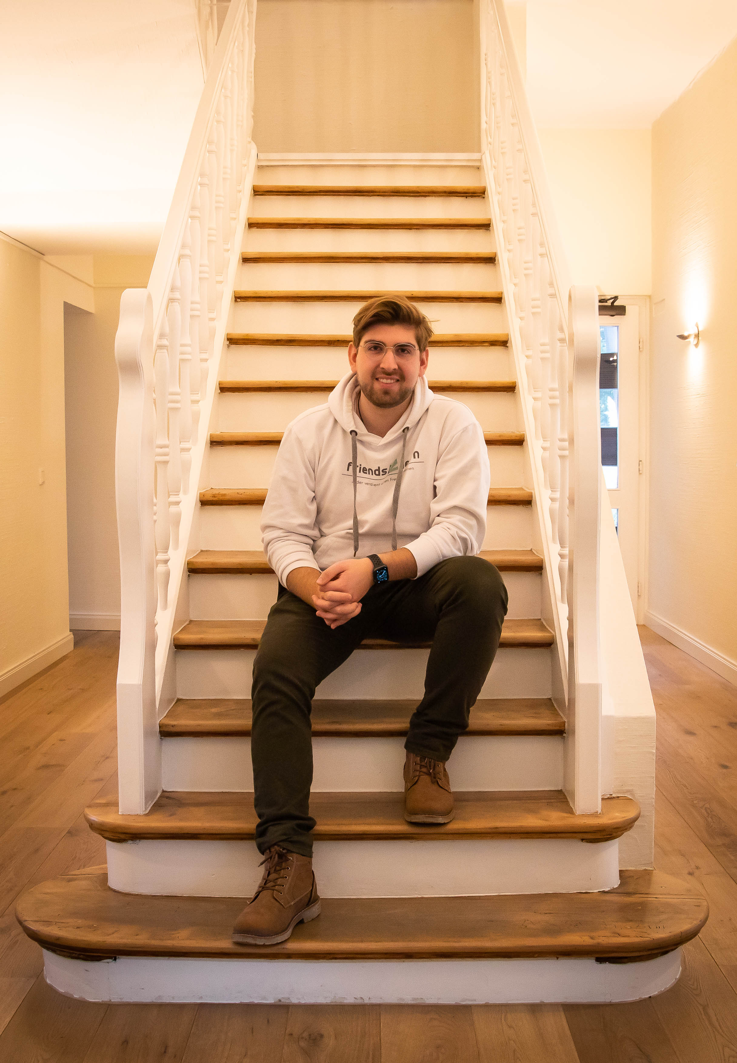 Yannick Rademacher sitzt auf einer Treppe